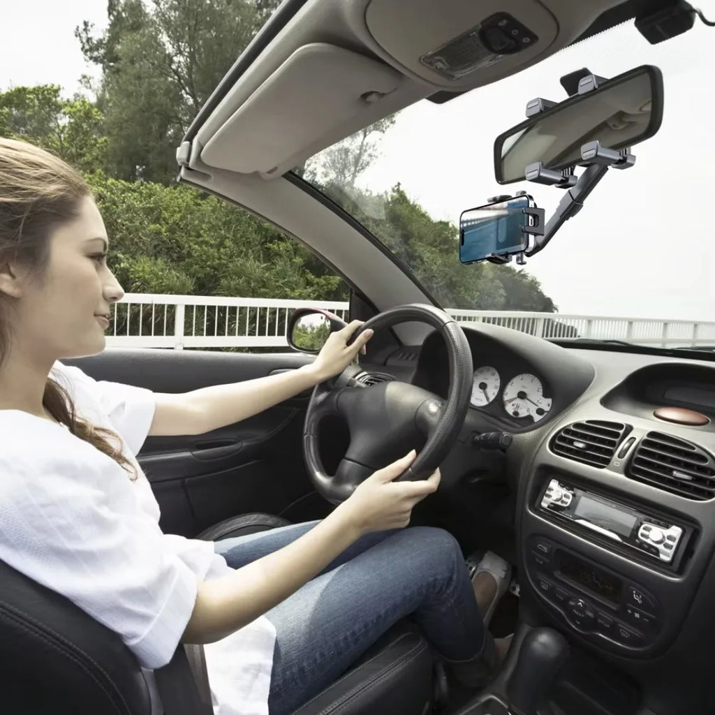 Woman driving a car with a smartphone mounted on a car holder.