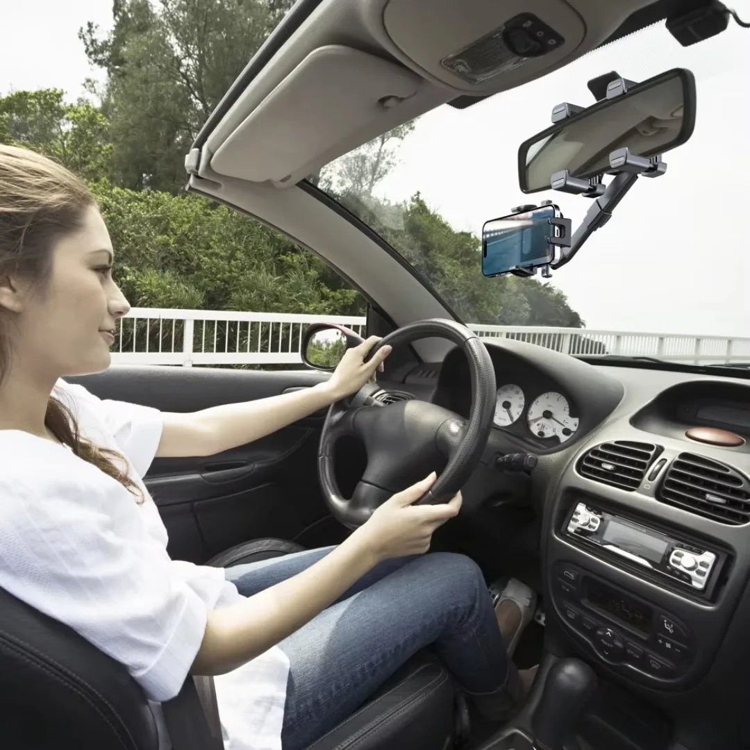 Woman driving a car with a smartphone mounted on a car holder.