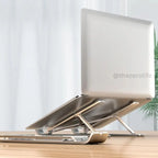 Laptop on a stand with a white screen on a wooden surface