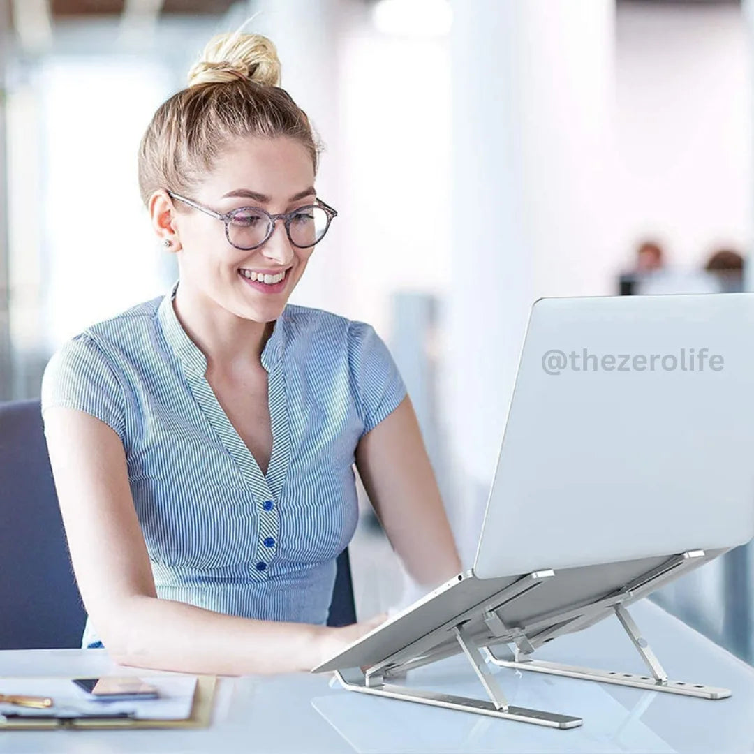 Woman using a laptop on a stand in an office setting