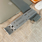 Laptop stand on a textured surface with a laptop and mouse in the background
