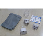 Set of travel adapters, a clear plastic cup, and a gray pouch on a beige surface.