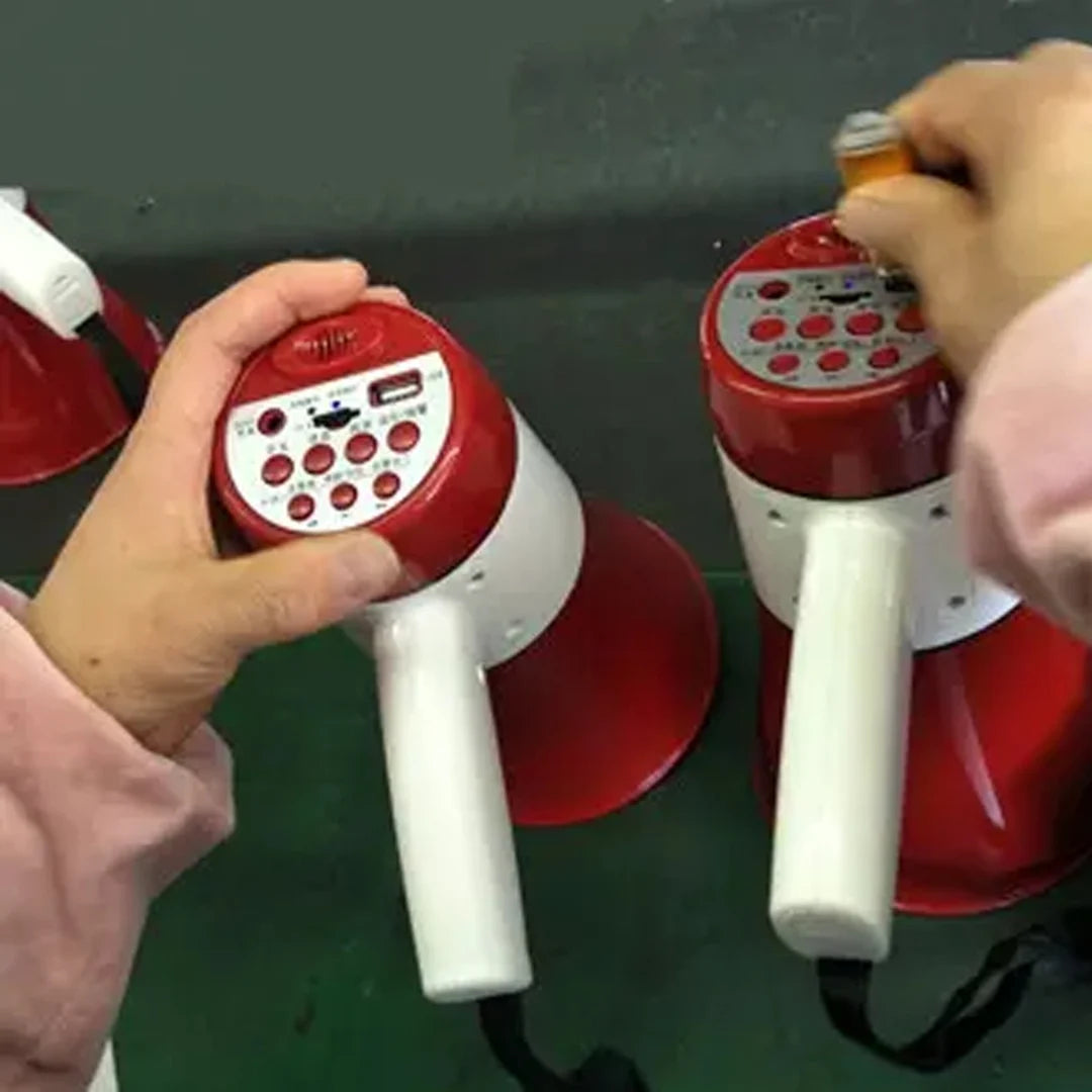 Red and white electronic devices with handles held by hands against a dark background