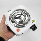 Hand holding a small electric stove with a white background