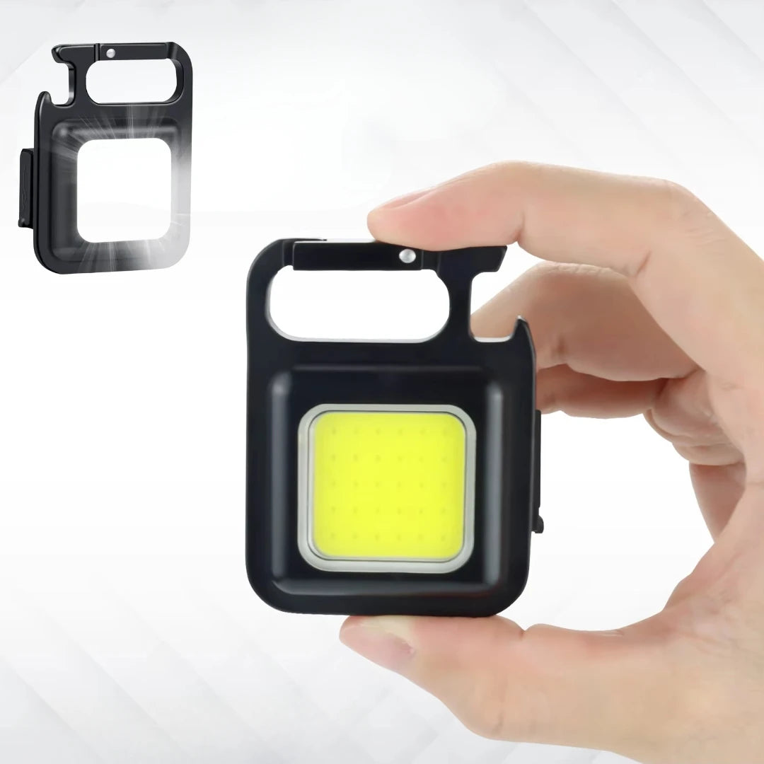 Hand holding a small black light with yellow center, inset with a similar product on a white background.