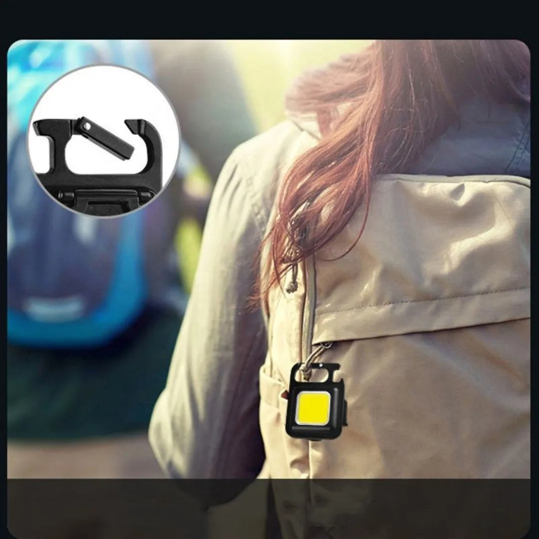 Person wearing a keychain light on a blurred outdoor background