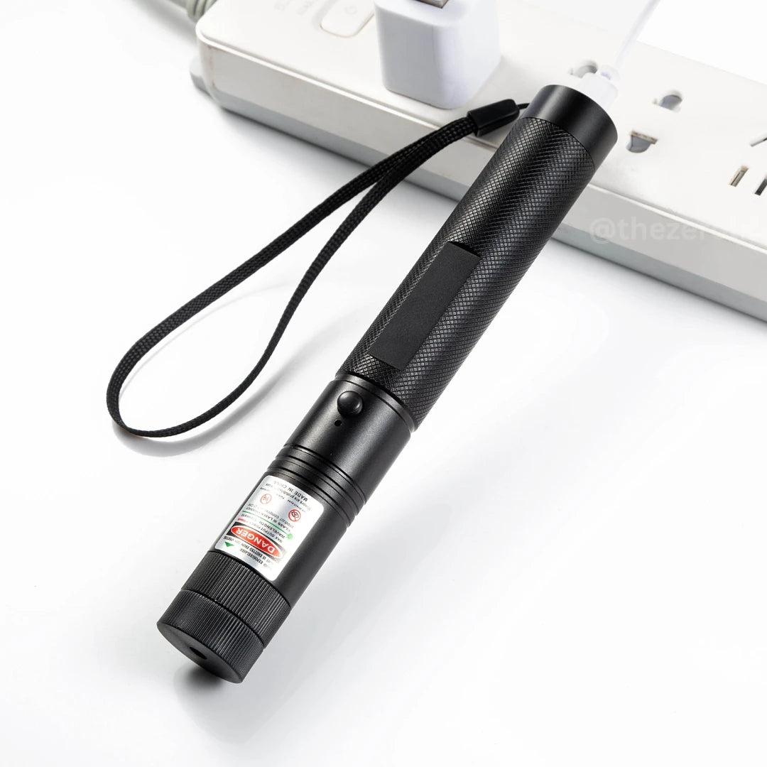 Black laser pointer on a white surface with a blurred background