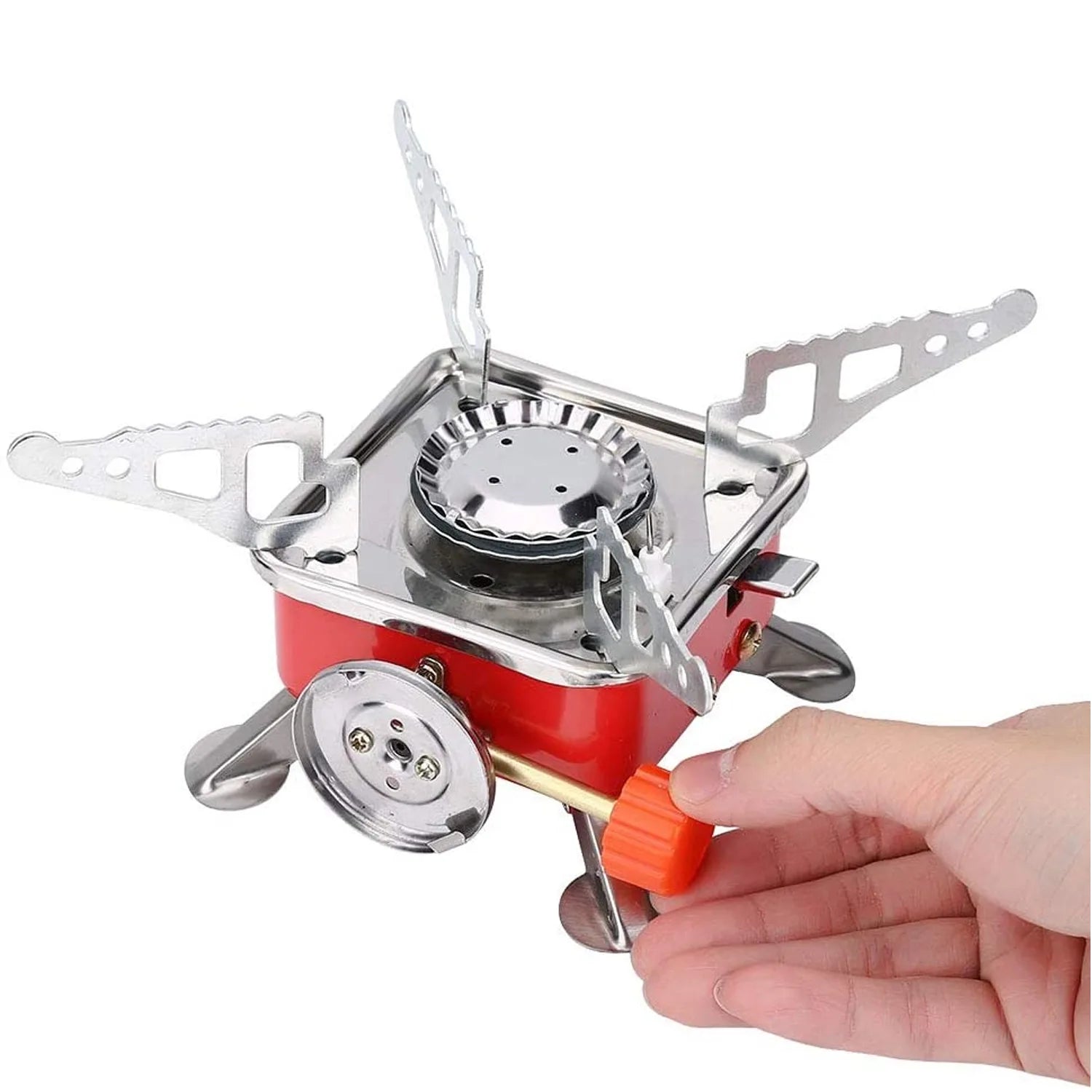 Hand holding a red and silver camping stove on a white background