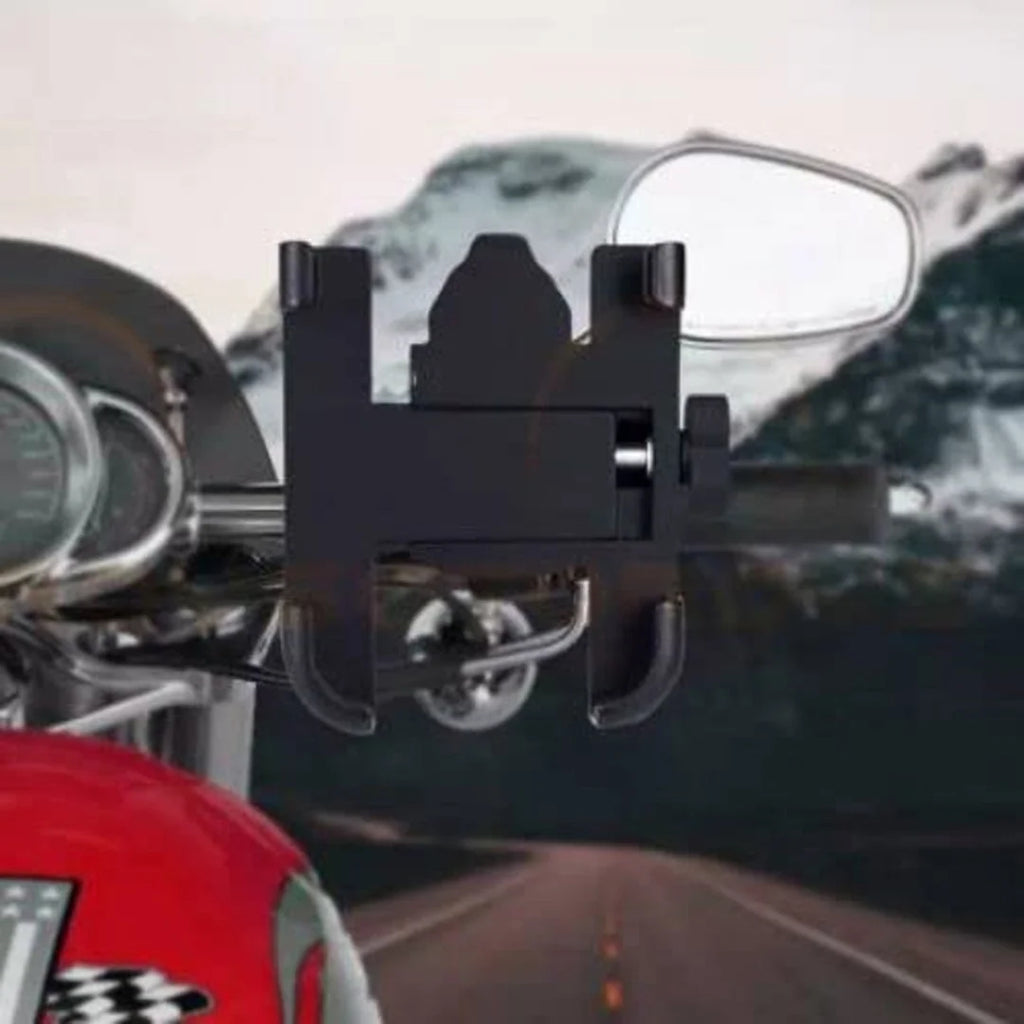 Close-up of a motorcycle with a black bracket attached to the side mirror, on a road with mountains in the background.