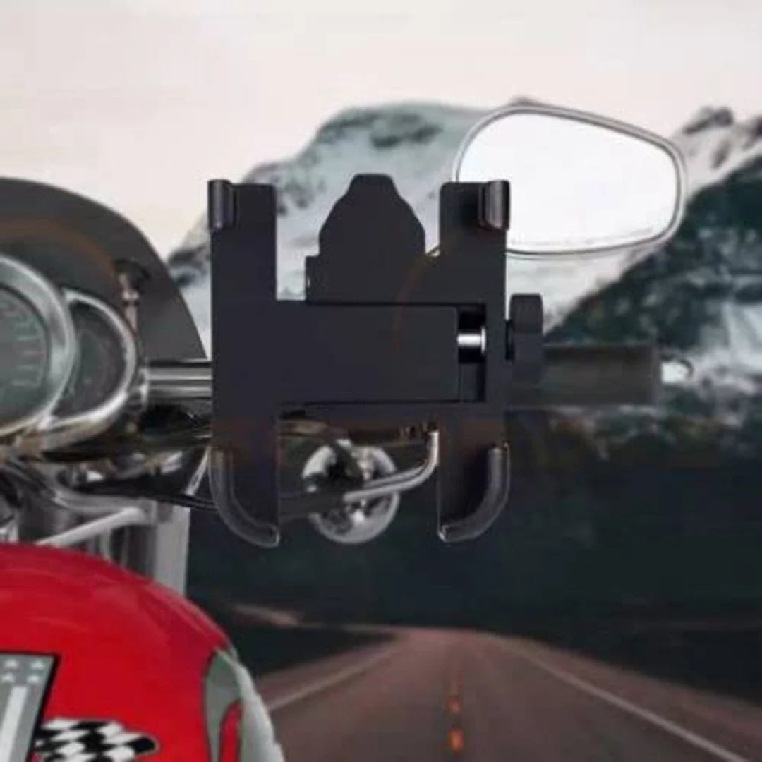 Close-up of a motorcycle with a black bracket attached to the side mirror, on a road with mountains in the background.